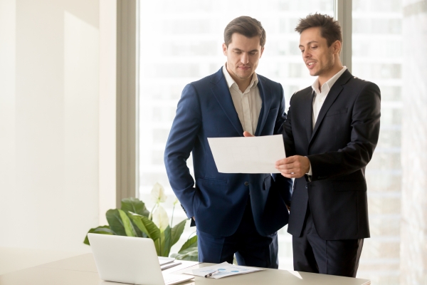 Benefits of a profit sharing plan being discussed by two corporate men.